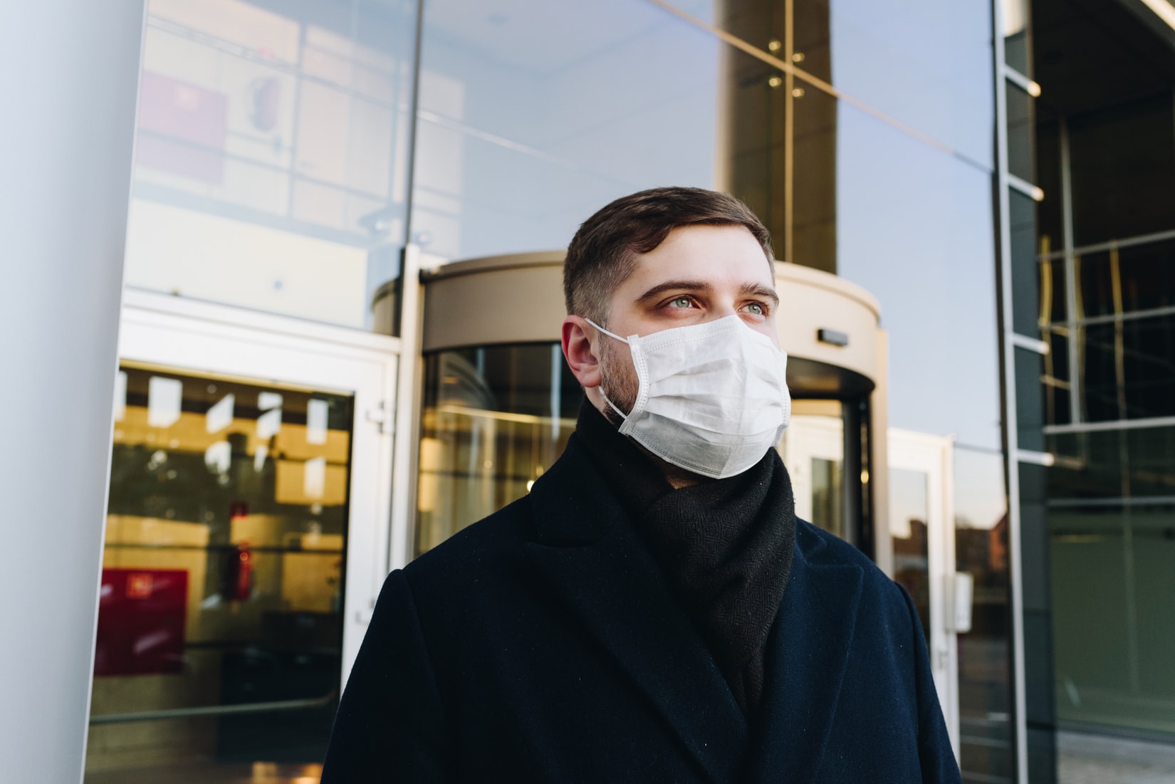 Man wearing mask in front of building